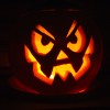 photo of an illuminated Jack O'Lantern with a michievious face carved on it